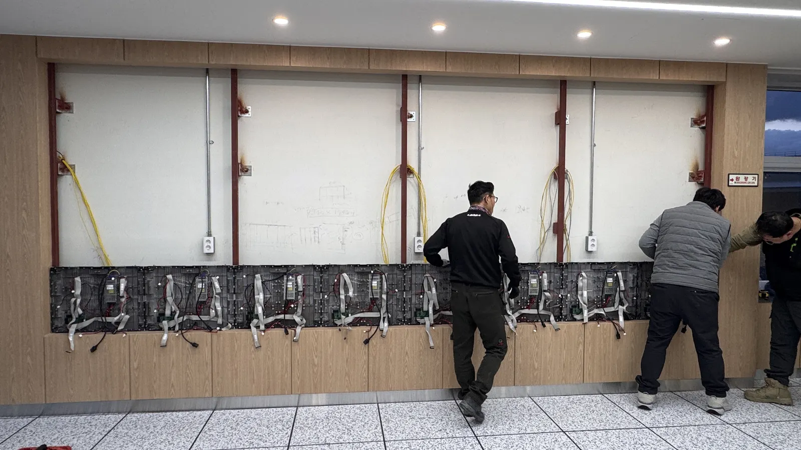 LED 캐비닛을 벽면에 설치하고 배선을 연결하는 과정